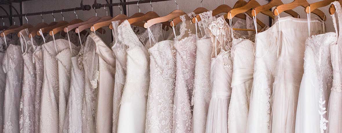 Bridal shop with bridal dresses on a rail.